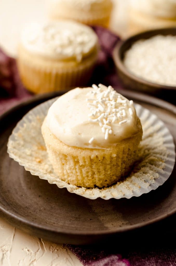 vanilla bean cupcake on a plate with the wrapper removed