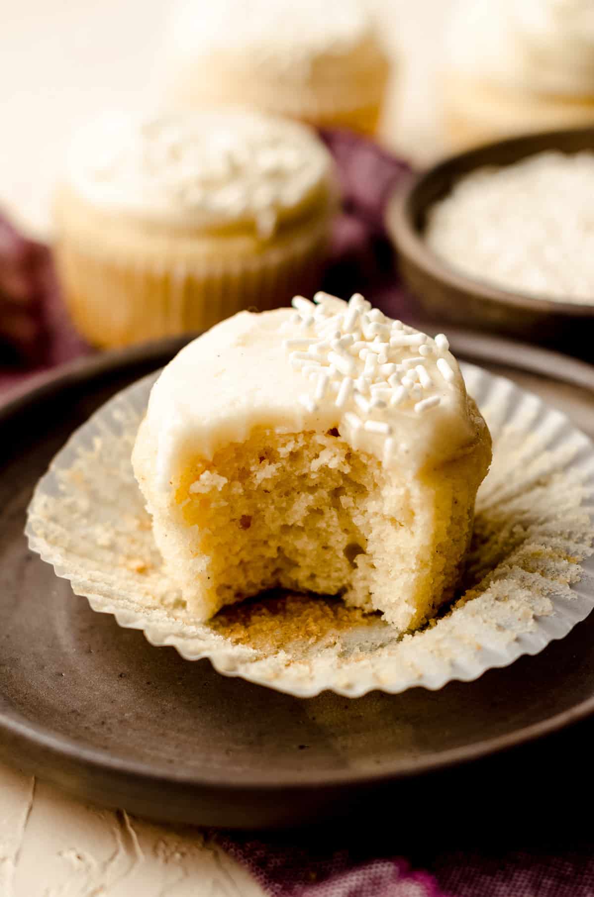 vanilla bean cupcake with a bite taken out of it