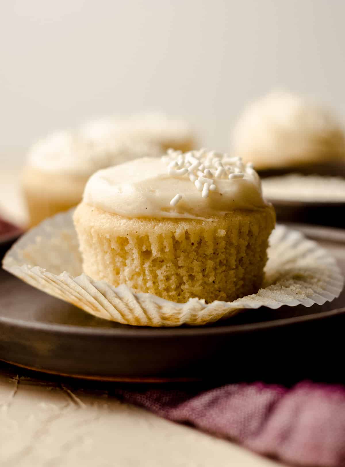 vanilla bean cupcake on a plate with the wrapper removed