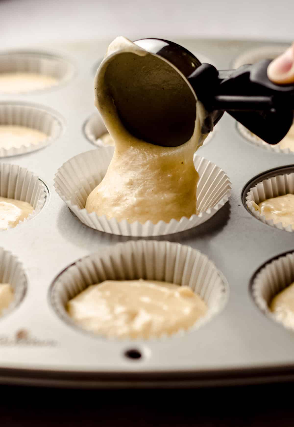 vanilla bean cupcake batter going into cupcake liners