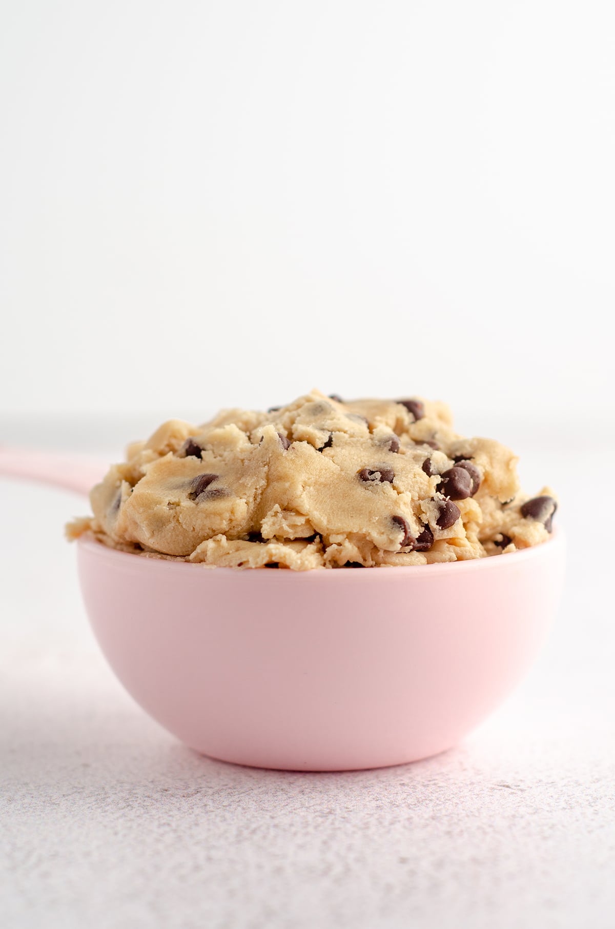 cookie dough in a pink measuring cup