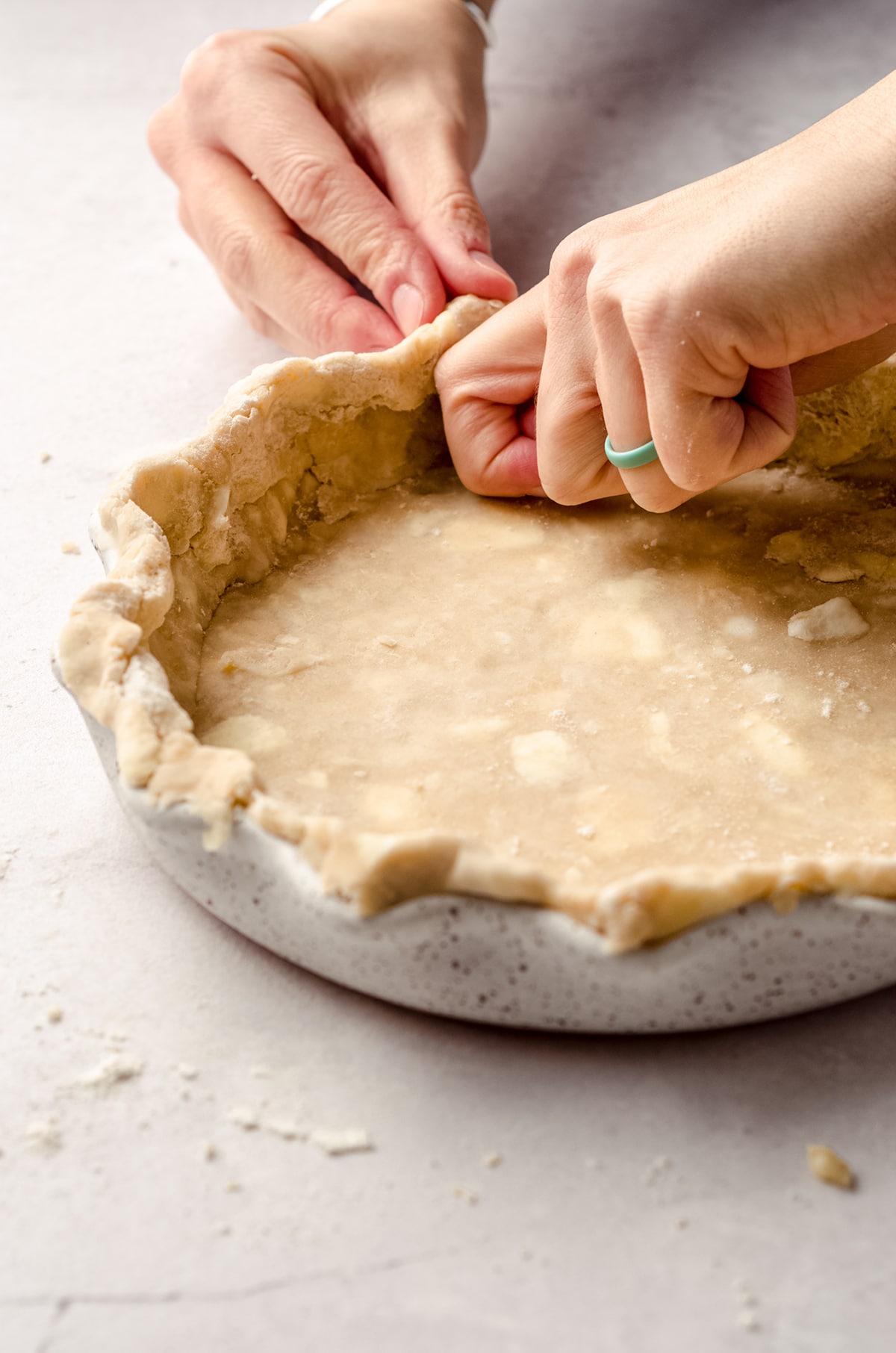 crimping a pie crust into a pie plate