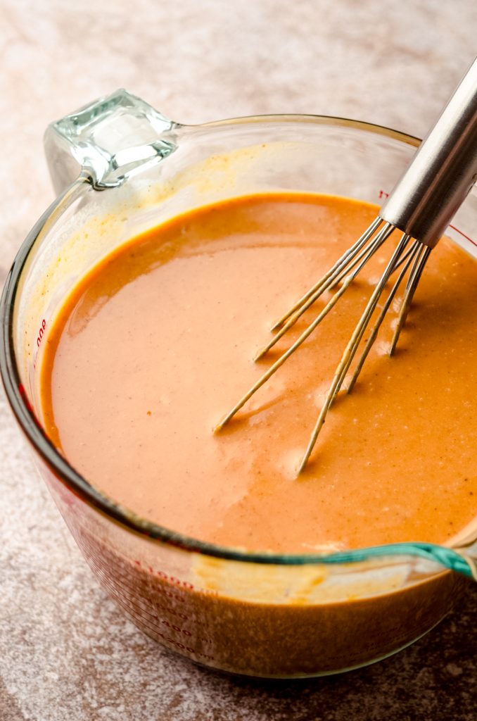 The ingredients for pumpkin pie in a large glass measuring cup after mixing together.