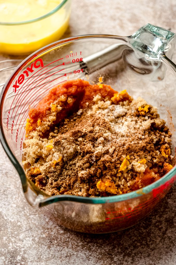 The ingredients for pumpkin pie in a large glass measuring cup before mixing together.