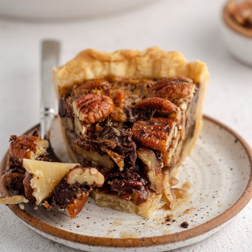 forkful taken out of a slice of chocolate chip pecan pie