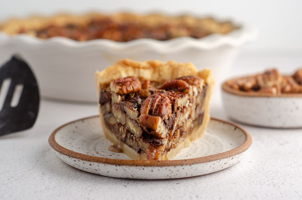 slice of chocolate chip pecan pie sitting on a plate