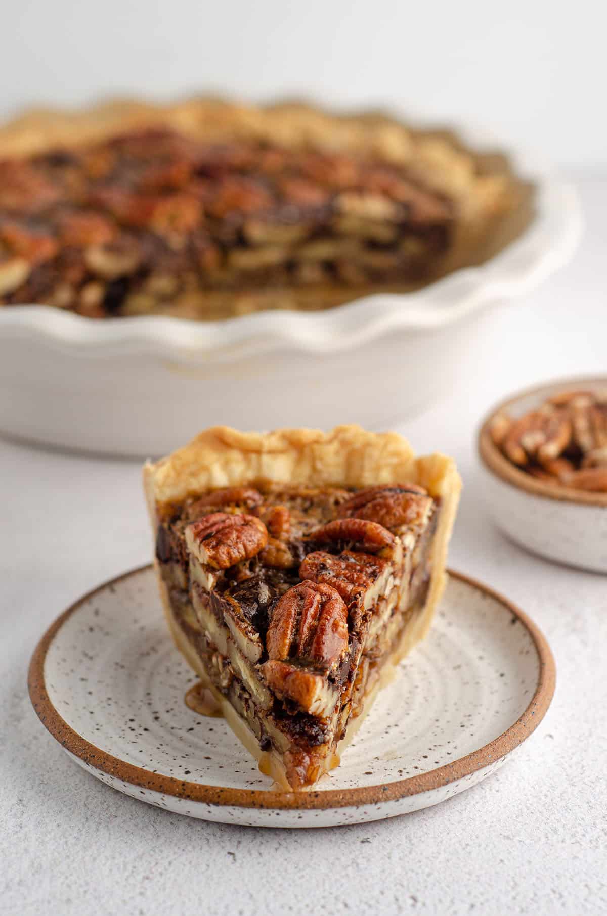 slice of chocolate chip pecan pie sitting on a plate