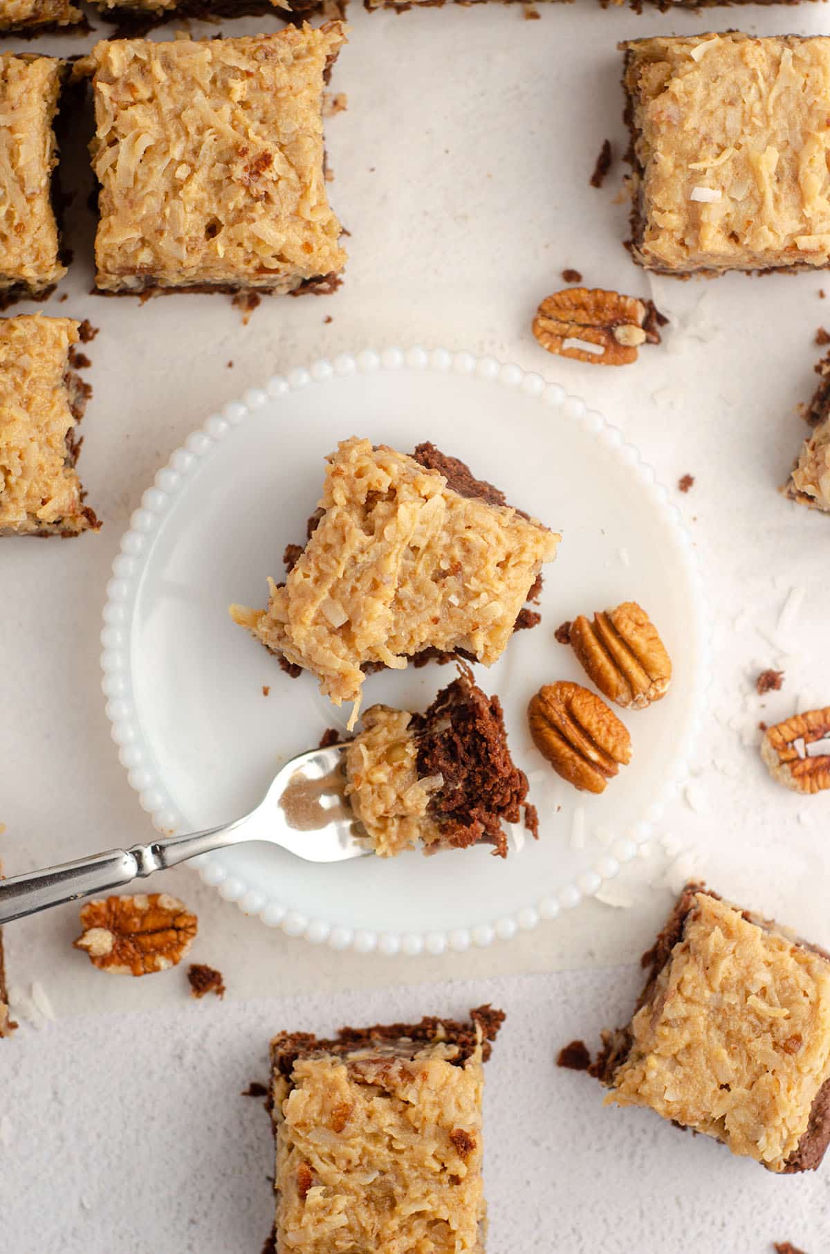 aerial photo of german chocolate brownie sitting on a plate with a fork full of a bite of the brownie