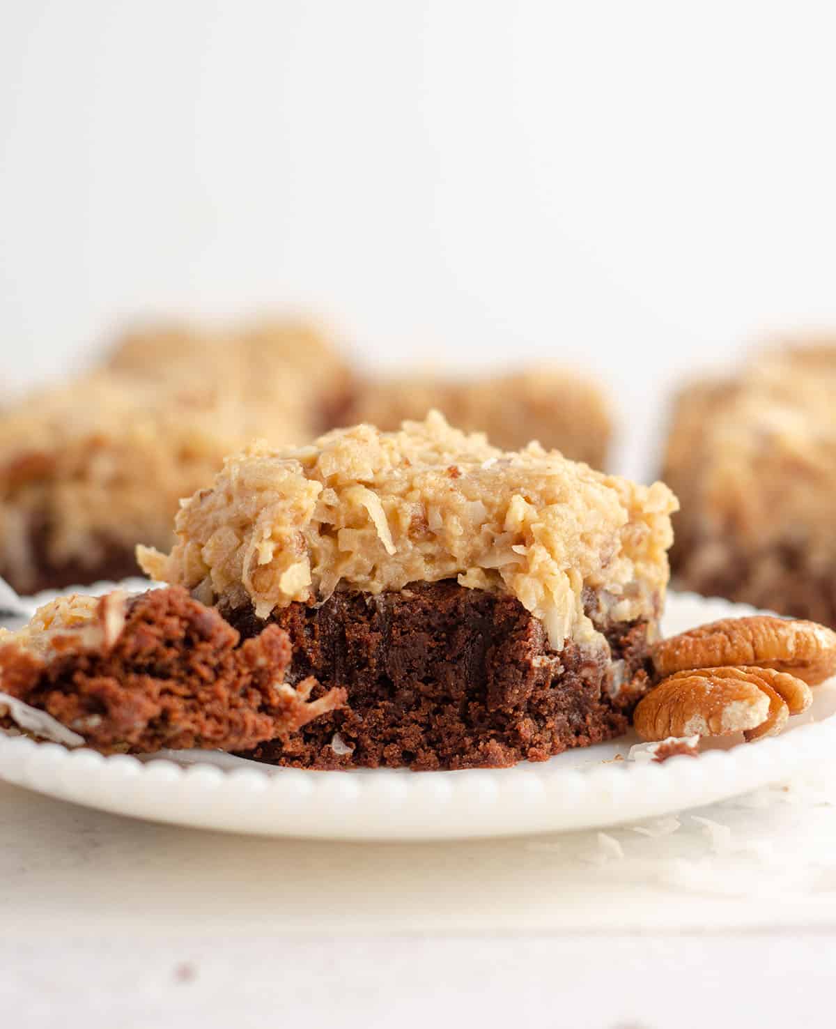 german chocolate brownie sitting on a plate with a fork full of a bite of the brownie