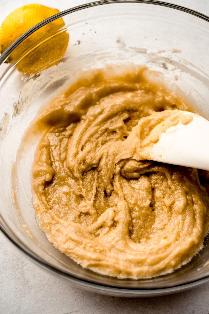 Someone is using a spatula to mix a bowl of the ingredients to make the crust for Meyer lemon bars.