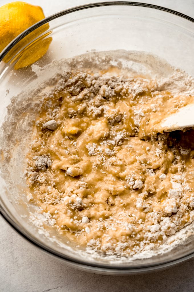 Someone is using a spatula to mix a bowl of the ingredients to make the crust for Meyer lemon bars.