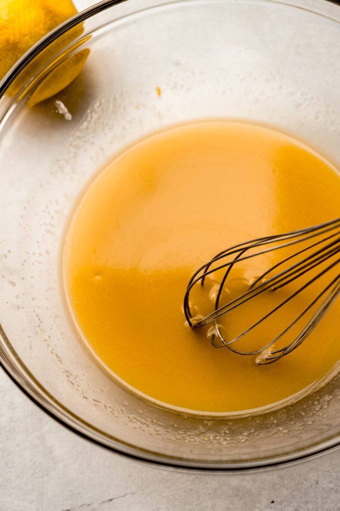 A bowl of the base for Meyer lemon bars with a whisk in it.