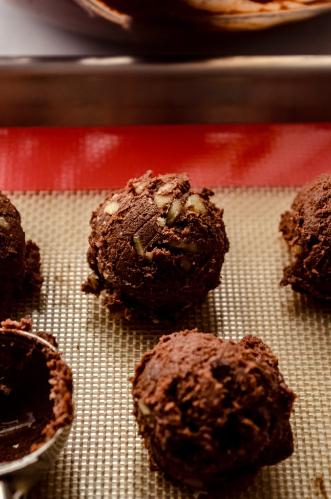 Balls of brownie cookie dough on a baking sheet.