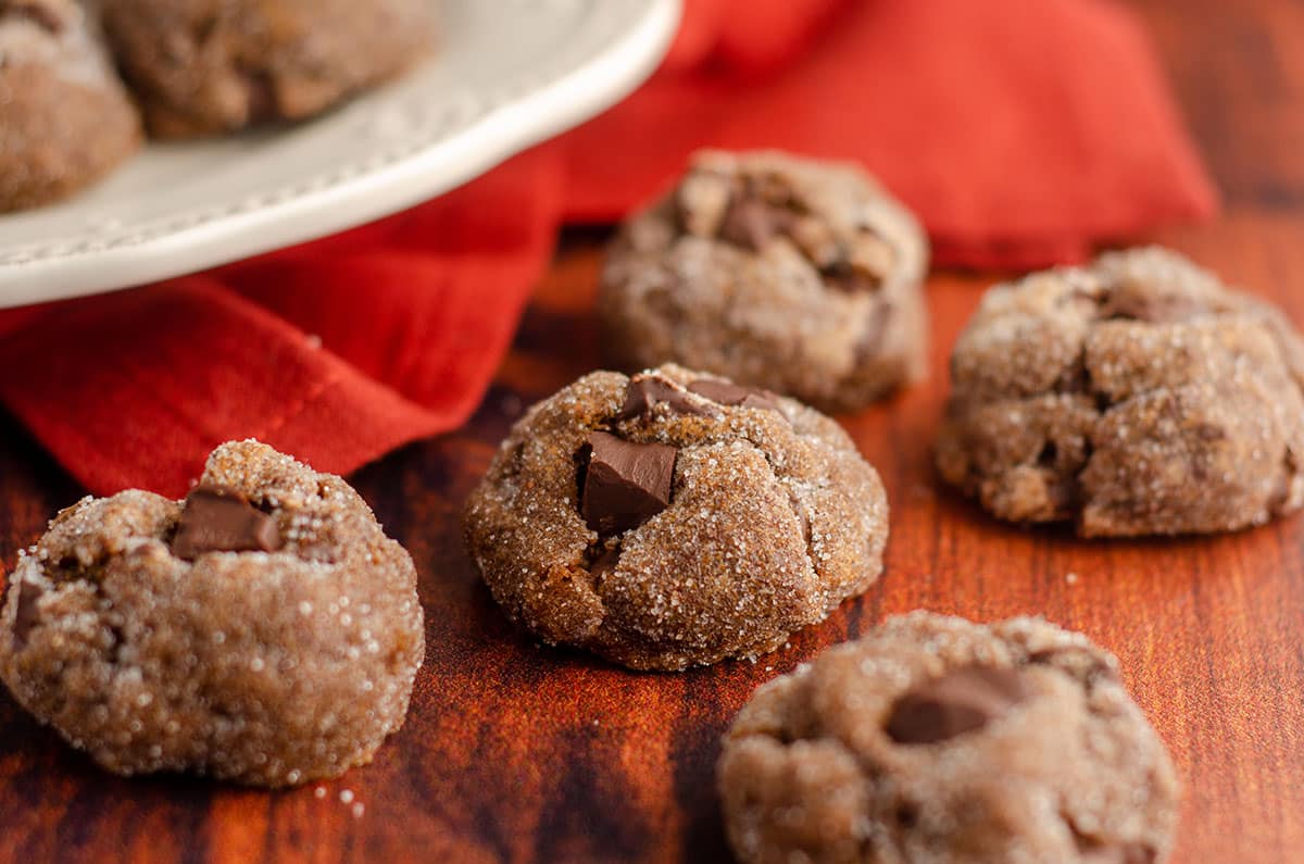 gingerbread chocolate cookie sitting on a wooden surface with burnt red kitchen towel behind it