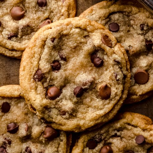 Aerial photo of chewy chocolate chip cookies on a surface.