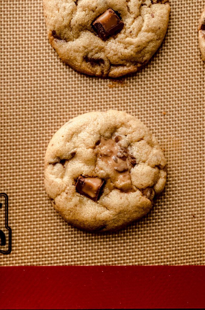 A peanut butter Rolo cookie on a baking sheet.