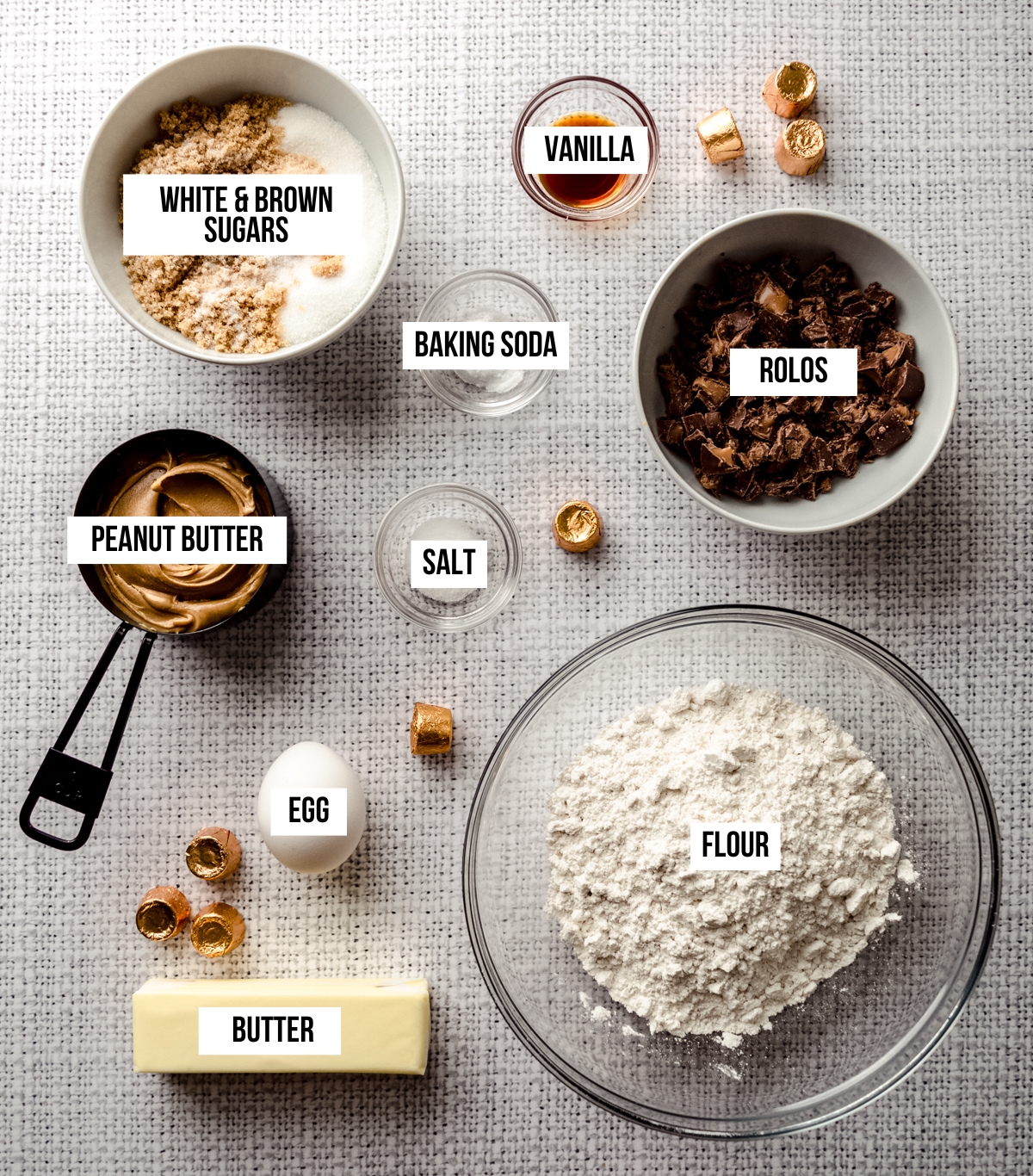 Aerial photo if ingredients to make peanut butter Rolo cookies with text overlay labeling each ingredient.