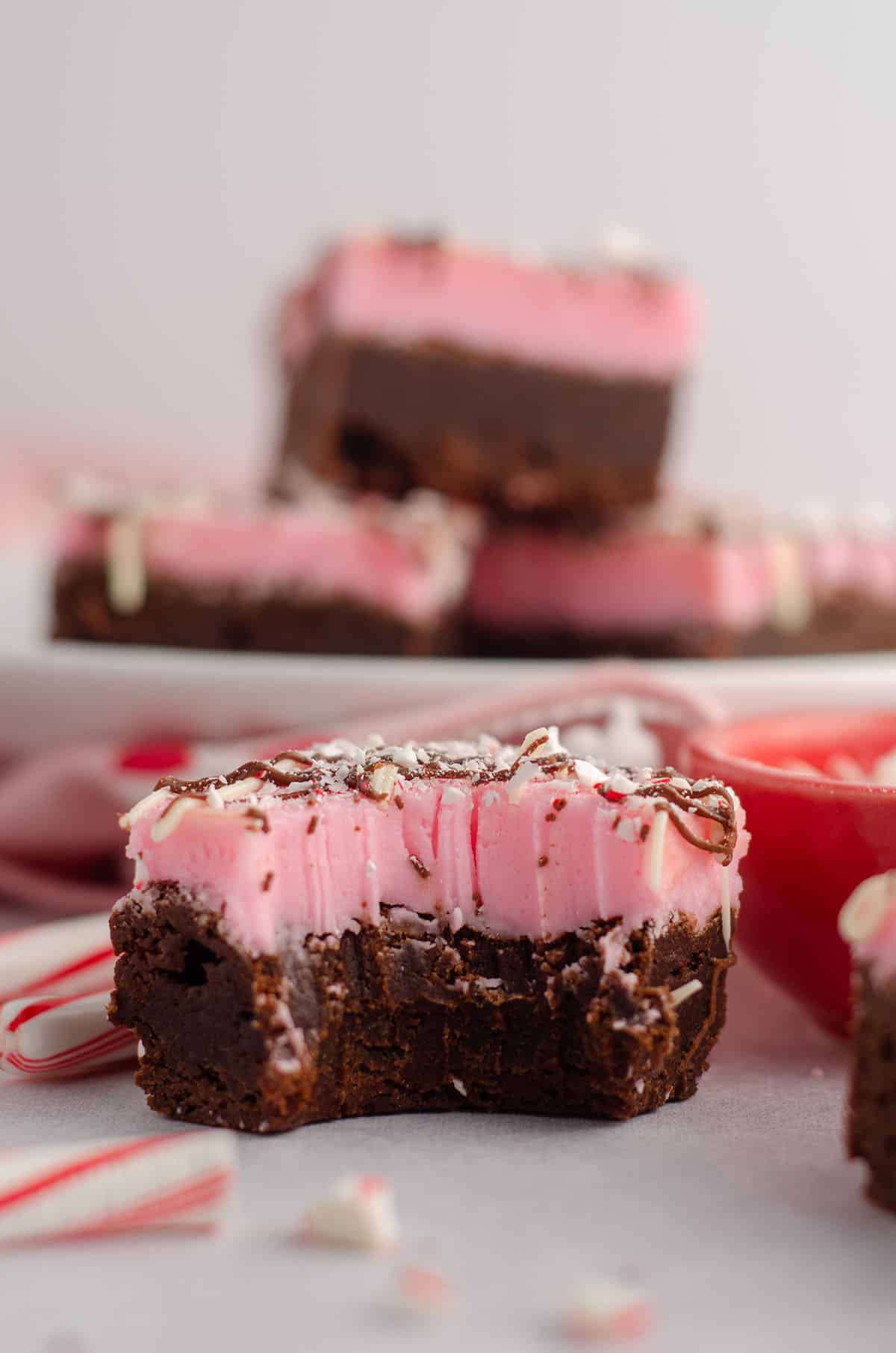 bite taken out of a peppermint brownie with crushed candy canes on top