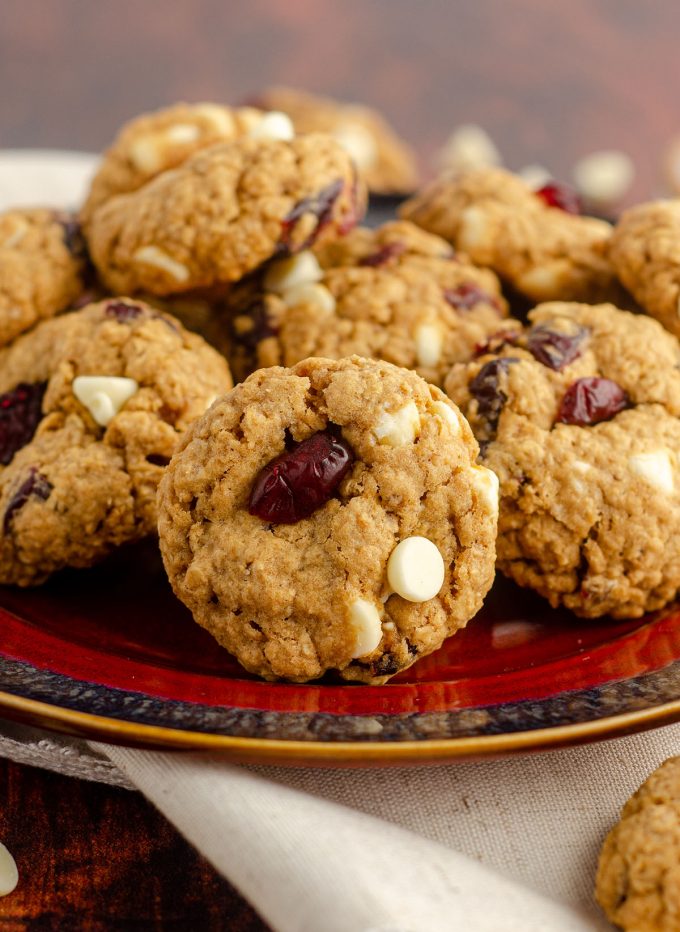 white chocolate cranberry oatmeal cookies sitting on a red and black plate