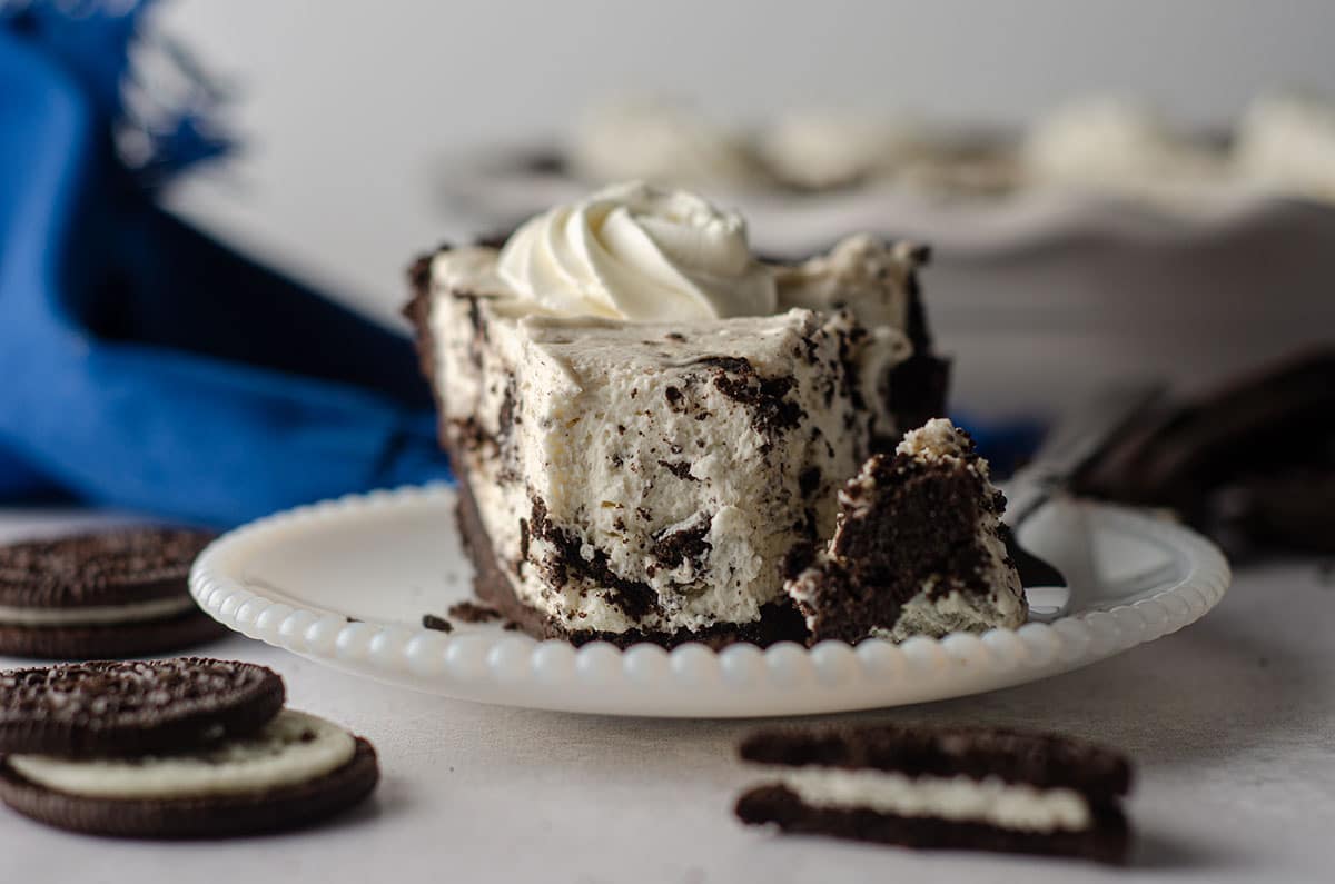 slice of no bake oreo pie sitting on a plate with a forkful taken out