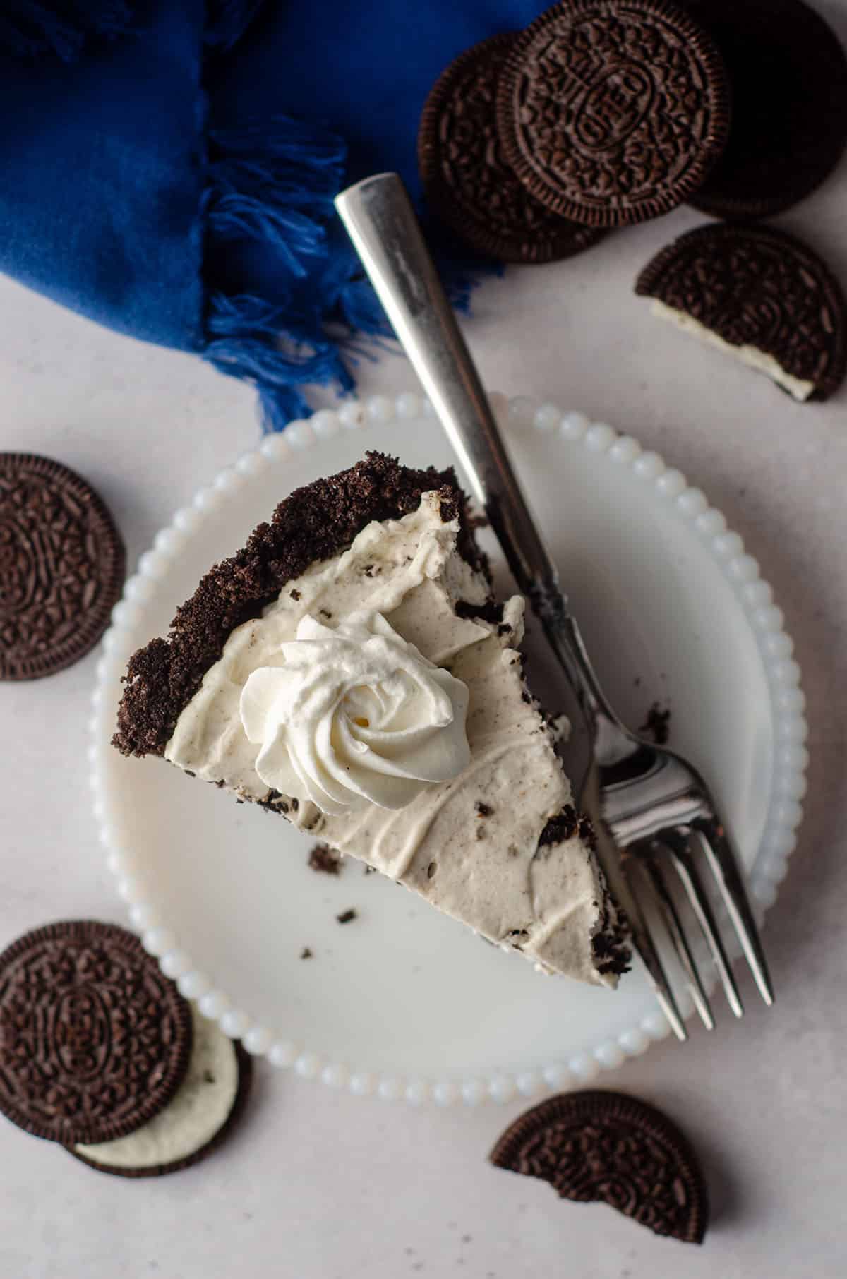 aerial photo of slice of no bake oreo pie sitting on a plate with a fork