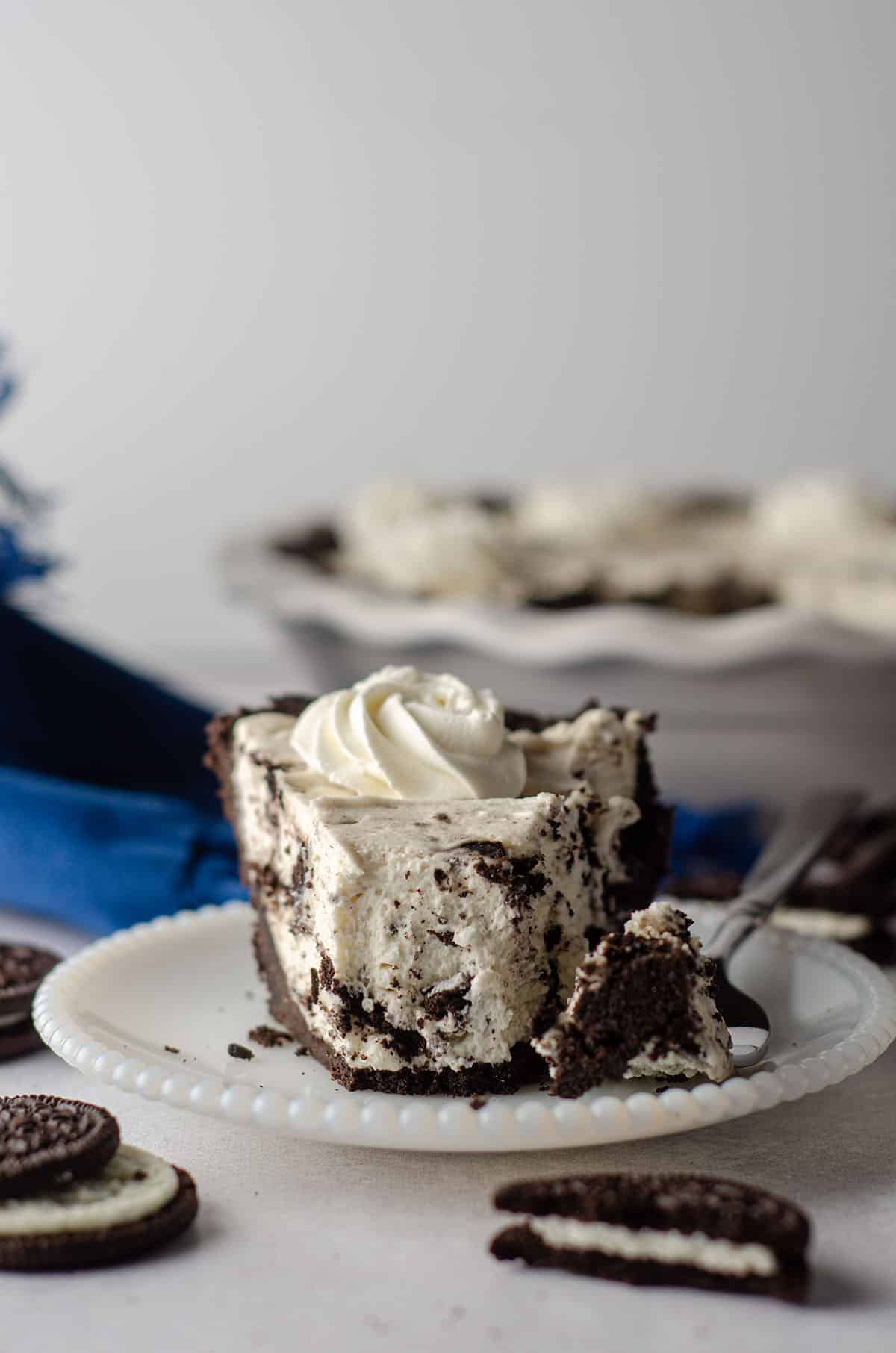 slice of no bake oreo pie sitting on a plate with a forkful taken out