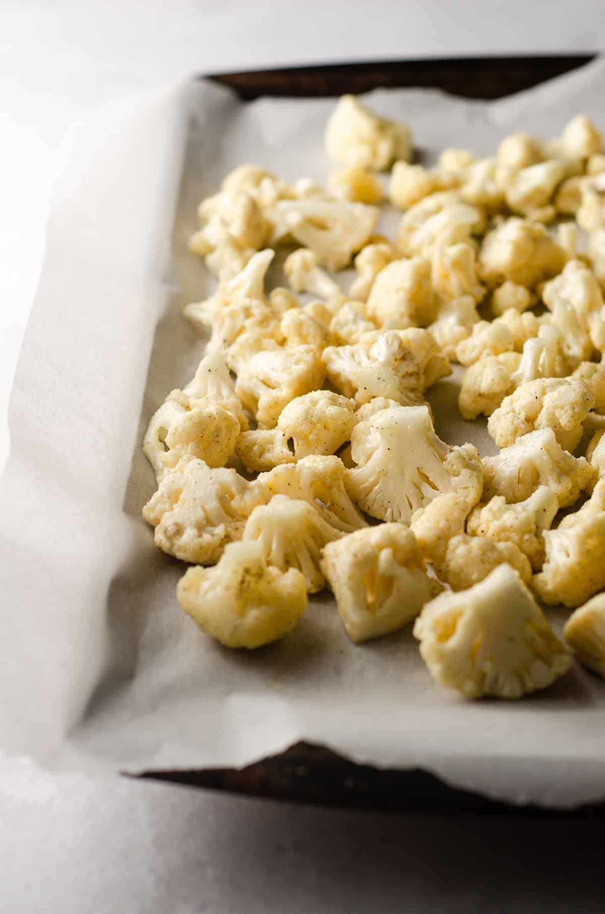 seasoned cauliflower on a baking sheet lined with parchment