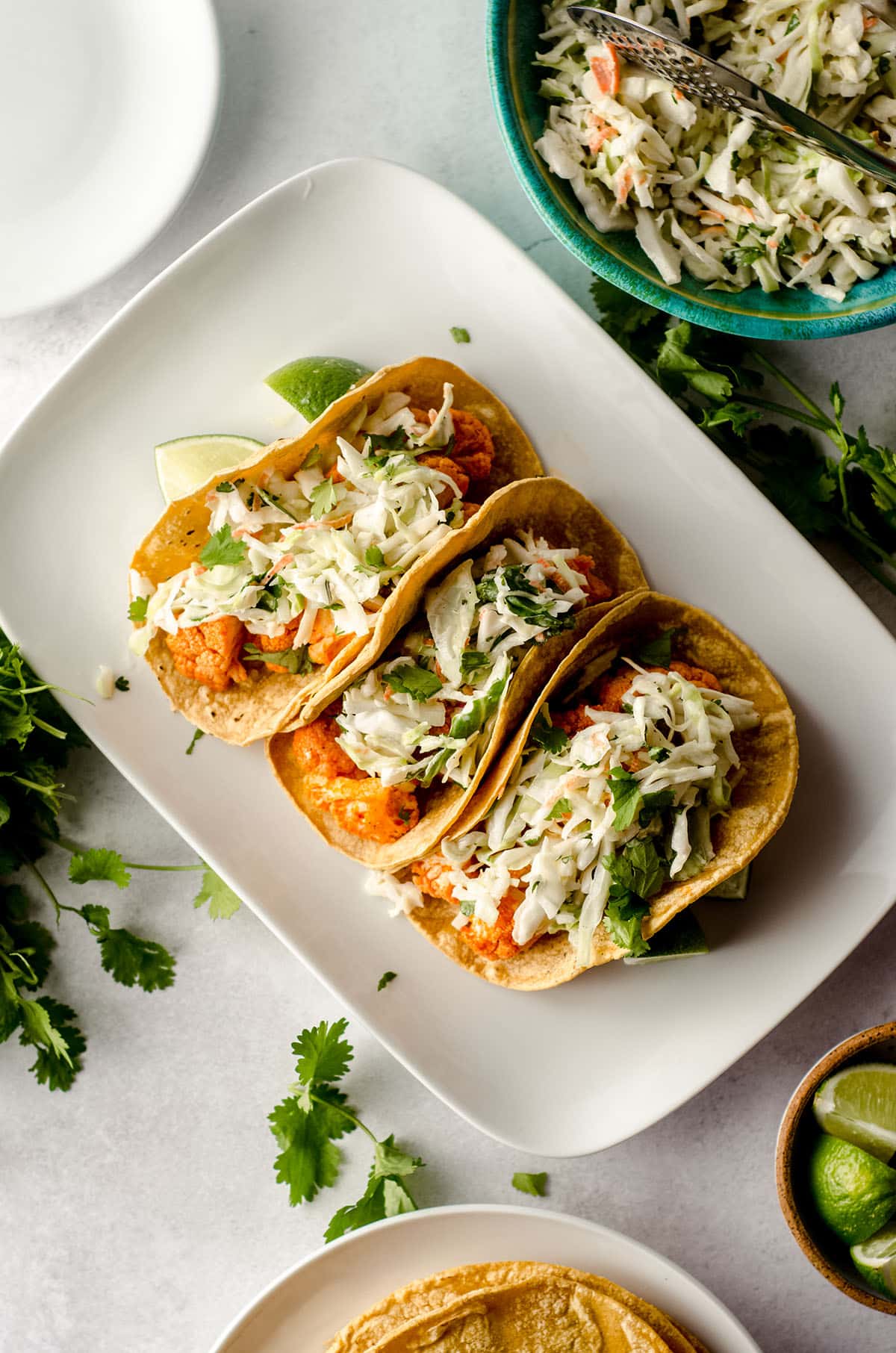 aerial photo of three buffalo cauliflower tacos sitting on a white platter