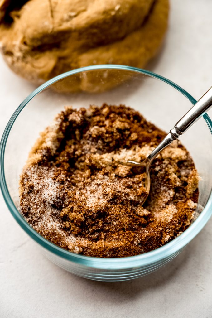 The filling for coffee cinnamon rolls in a small glass bowl with a spoon.