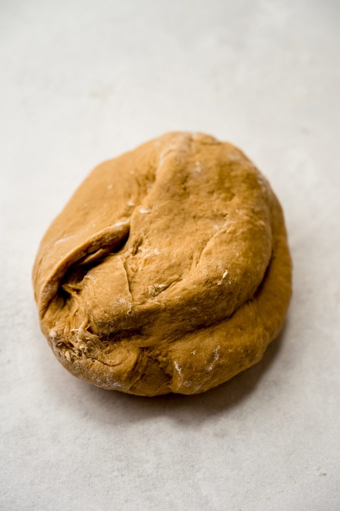 Dough for coffee rolls in a smooth ball on a surface.