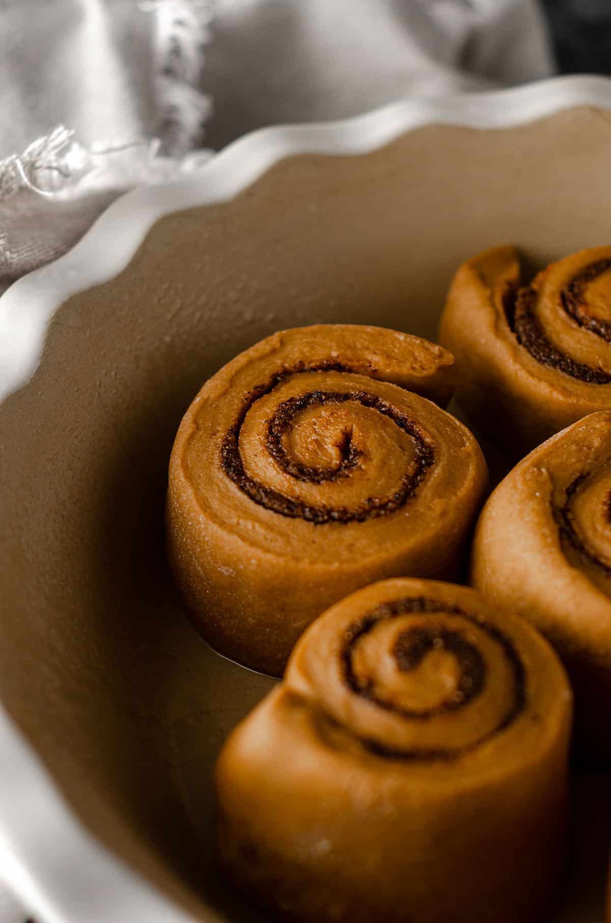 coffee cinnamon roll dough in a pie dish ready to rise