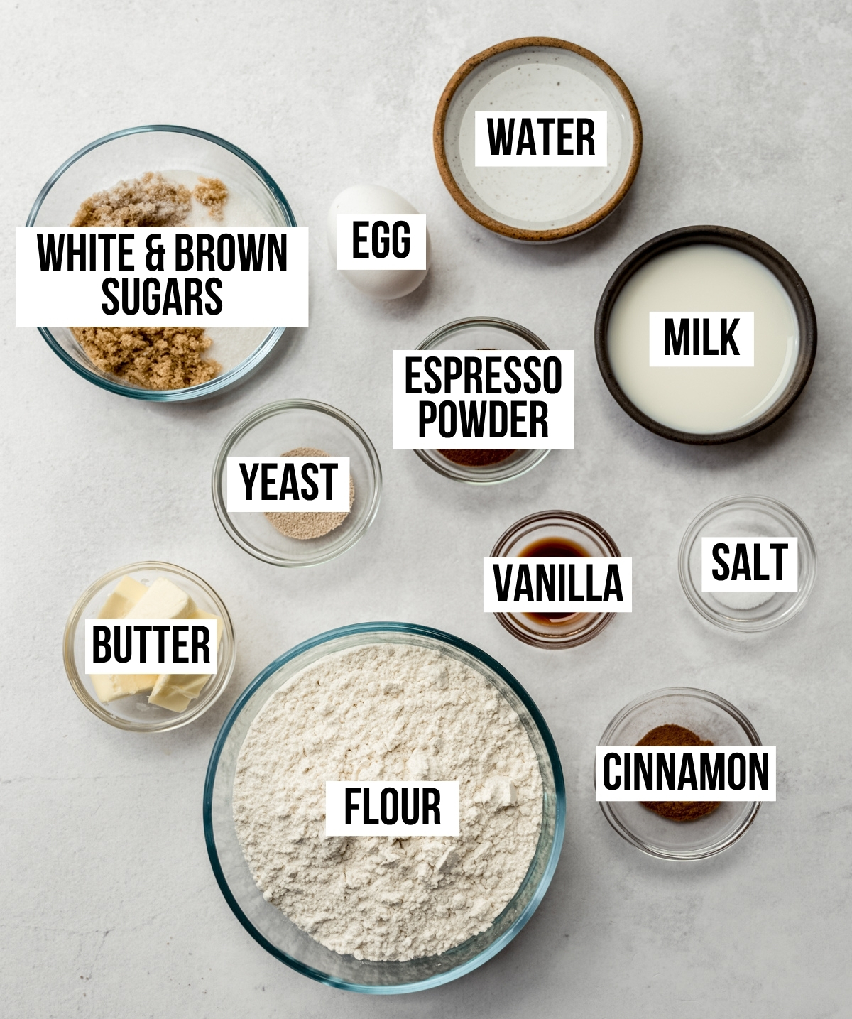 Aerial photo of the ingredients to make coffee cinnamon rolls with text overlay labeling each ingredient.