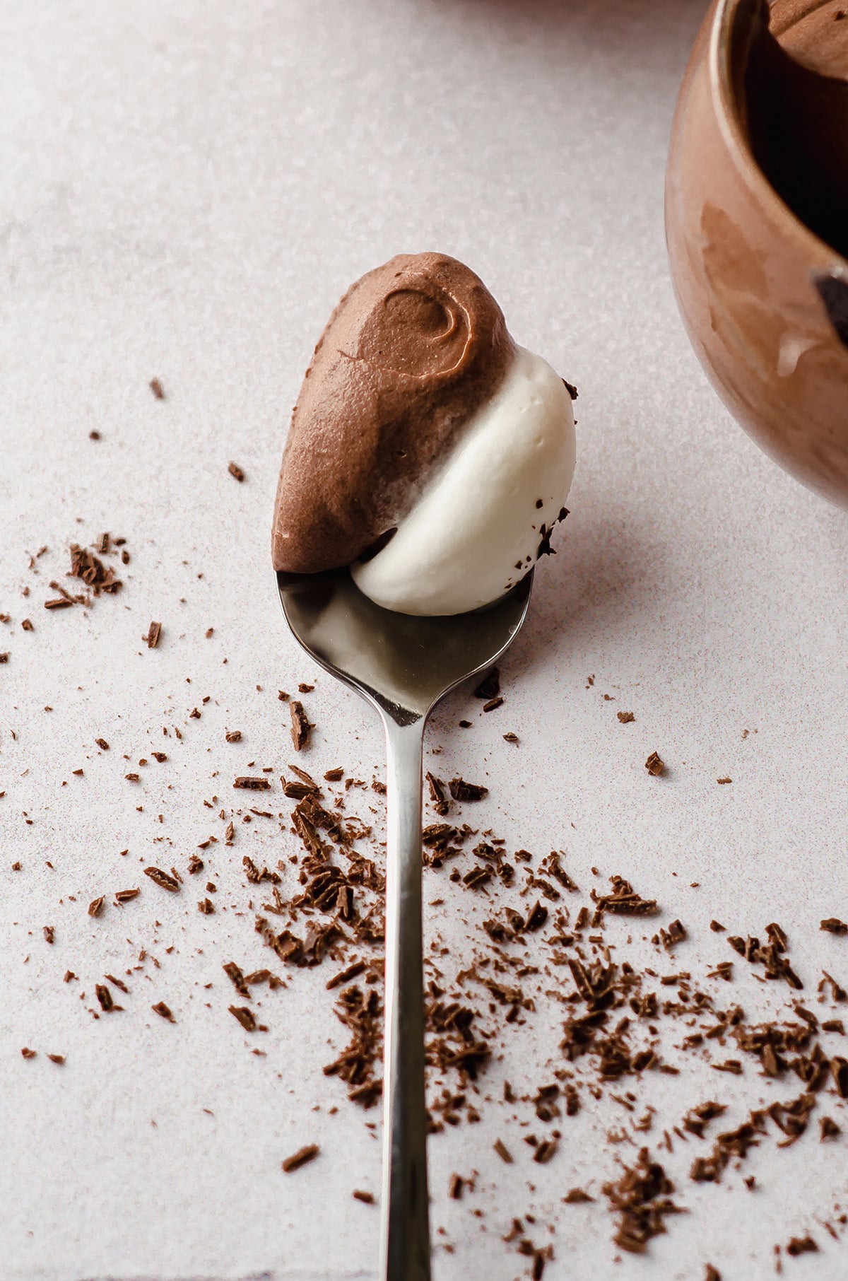 spoon with a scoop of chocolate mousse and whipped cream on it