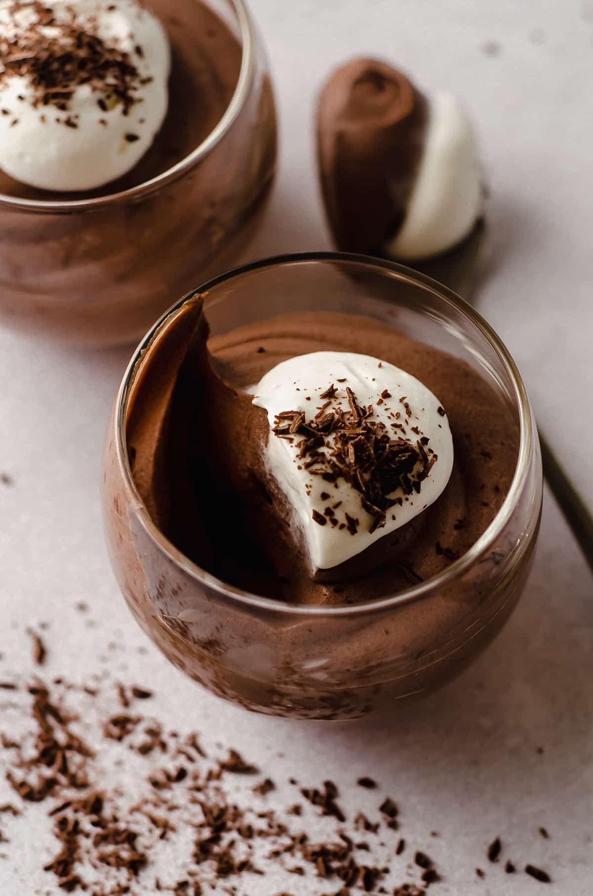 dessert cup of chocolate mousse with a scoop taken out of it