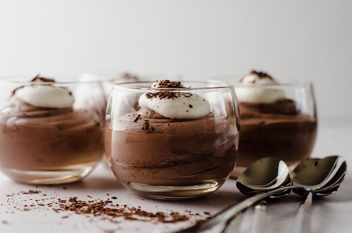 dessert cups filled with easy chocolate mousse topped with whipped cream and shaved chocolate