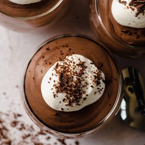 aerial photo of a dessert cup filled with chocolate mousse with whipped cream and shaved chocolate on top
