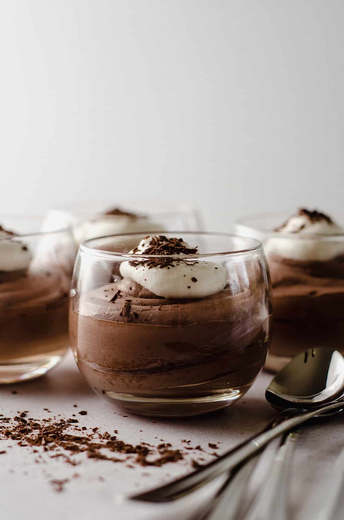 dessert cups filled with easy chocolate mousse topped with whipped cream and shaved chocolate