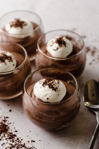 dessert cups filled with easy chocolate mousse topped with whipped cream and shaved chocolate