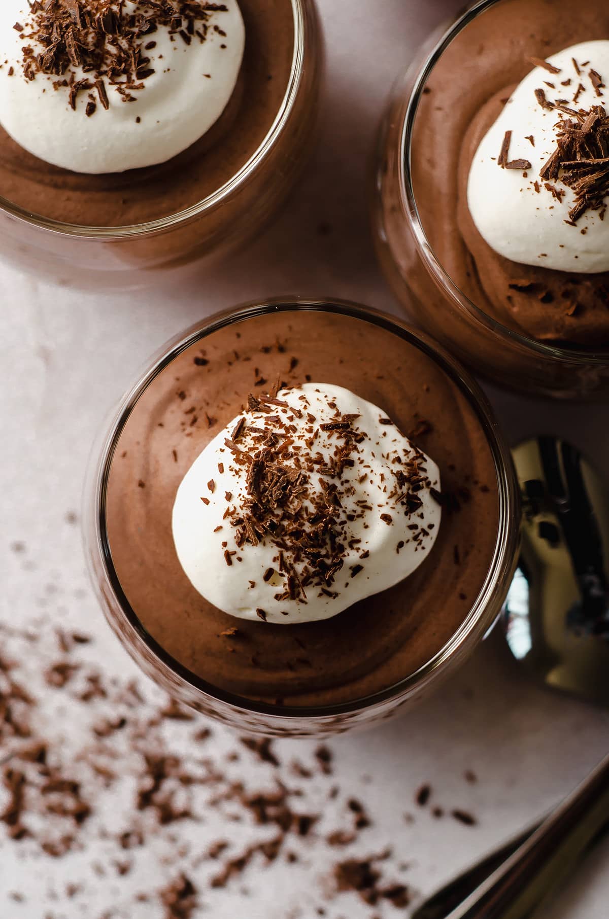 aerial photo of a dessert cup filled with chocolate mousse with whipped cream and shaved chocolate on top
