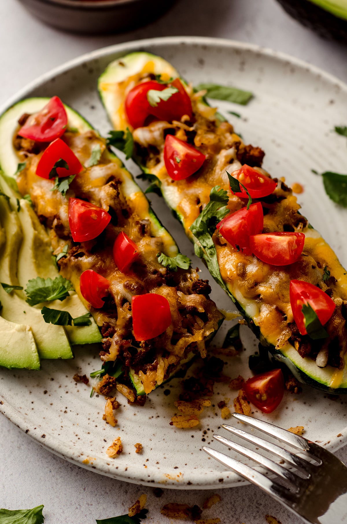 taco zucchini boats on a plate with a bite taken out of one
