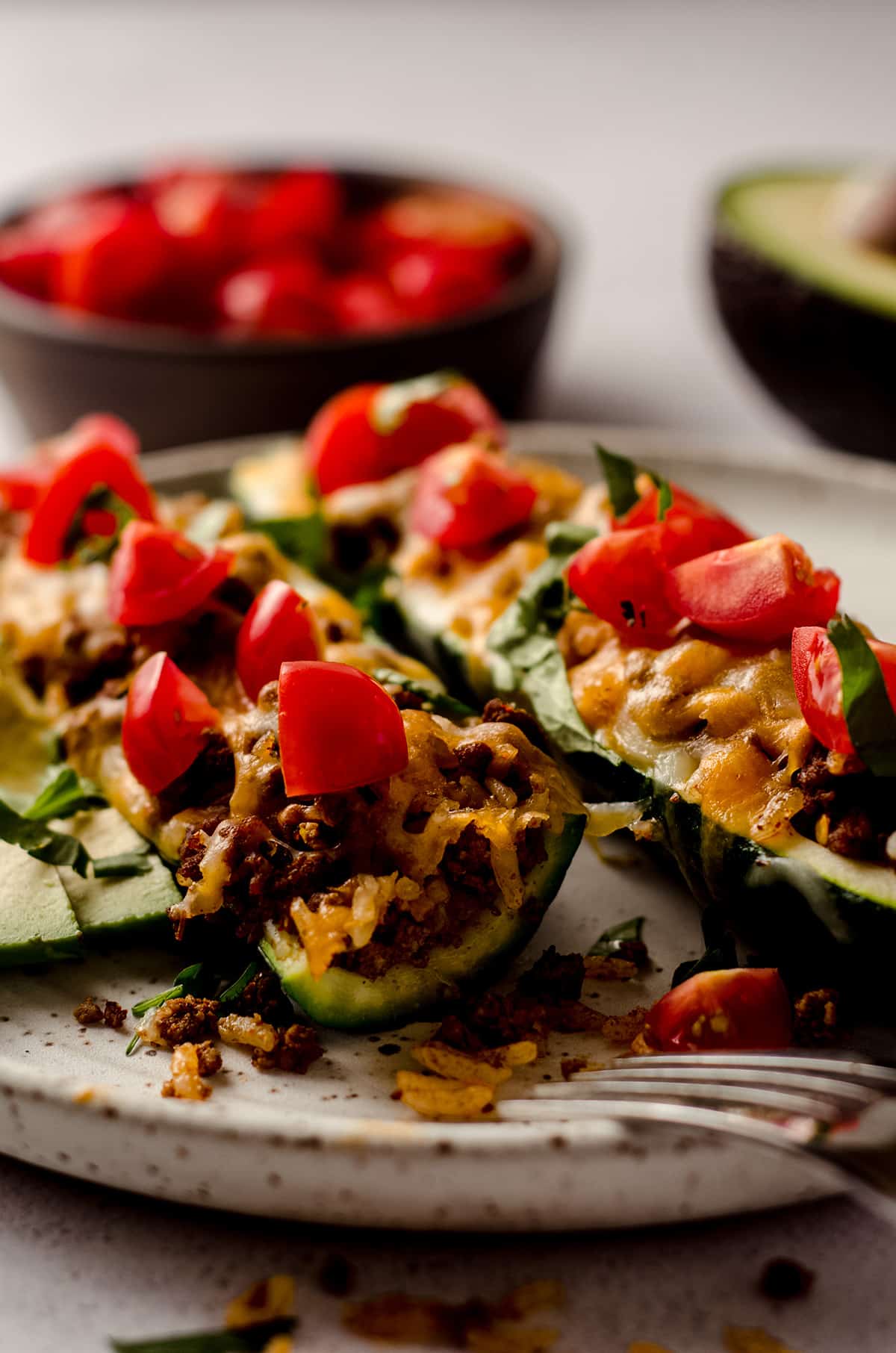 taco zucchini boats on a plate with a bite taken out of one