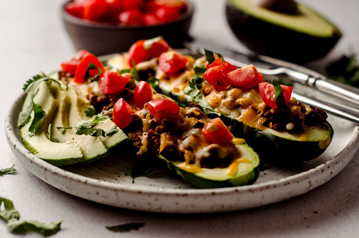 taco zucchini boats on a plate with a fork and a knife