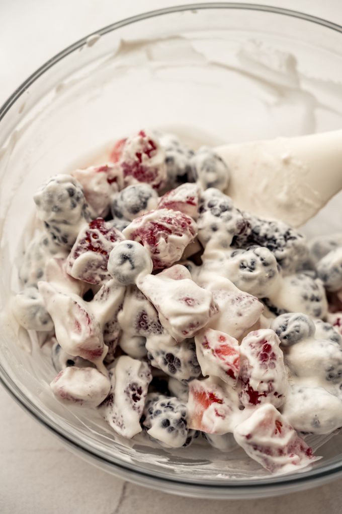 A bowl of fresh berries and whipped cream.