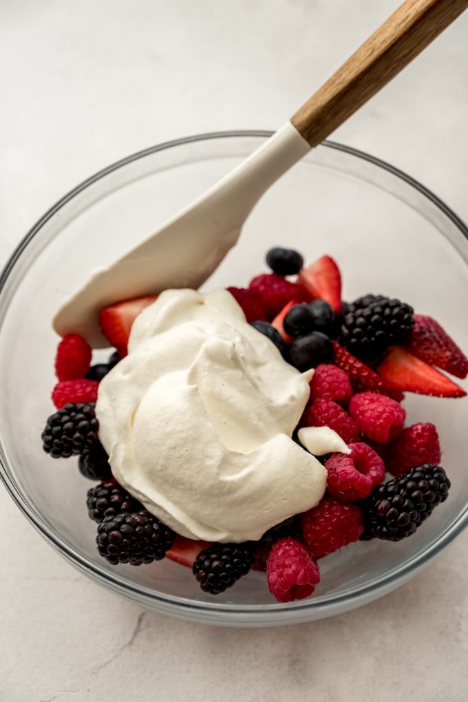 A bowl of fresh berries and whipped cream.