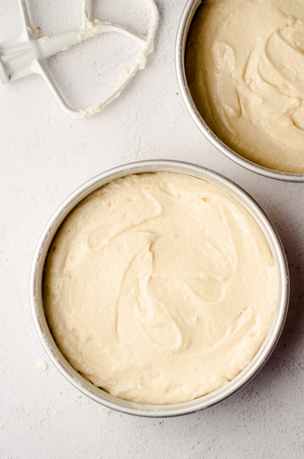 white layer cake batter in round cake pans ready to bake