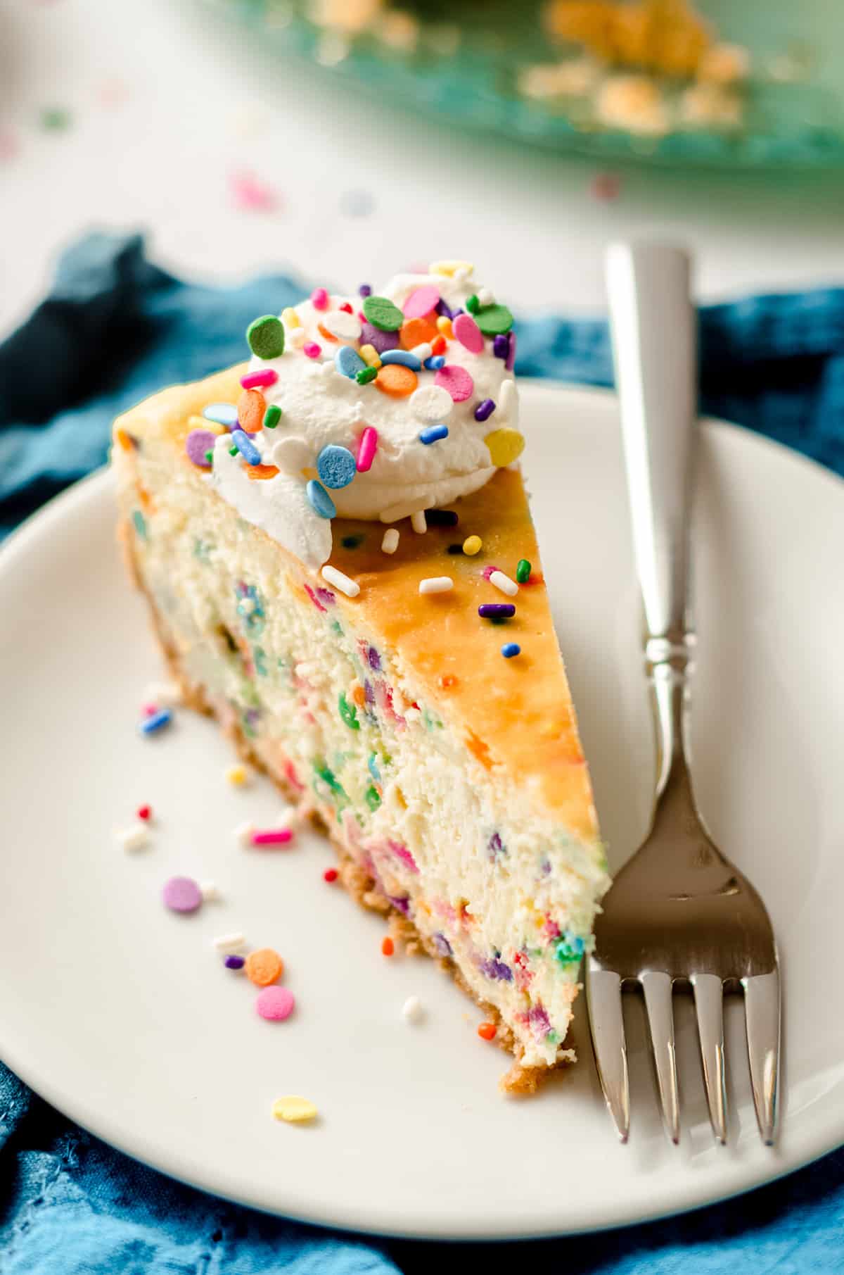 slice of funfetti cheesecake on a plate with a fork