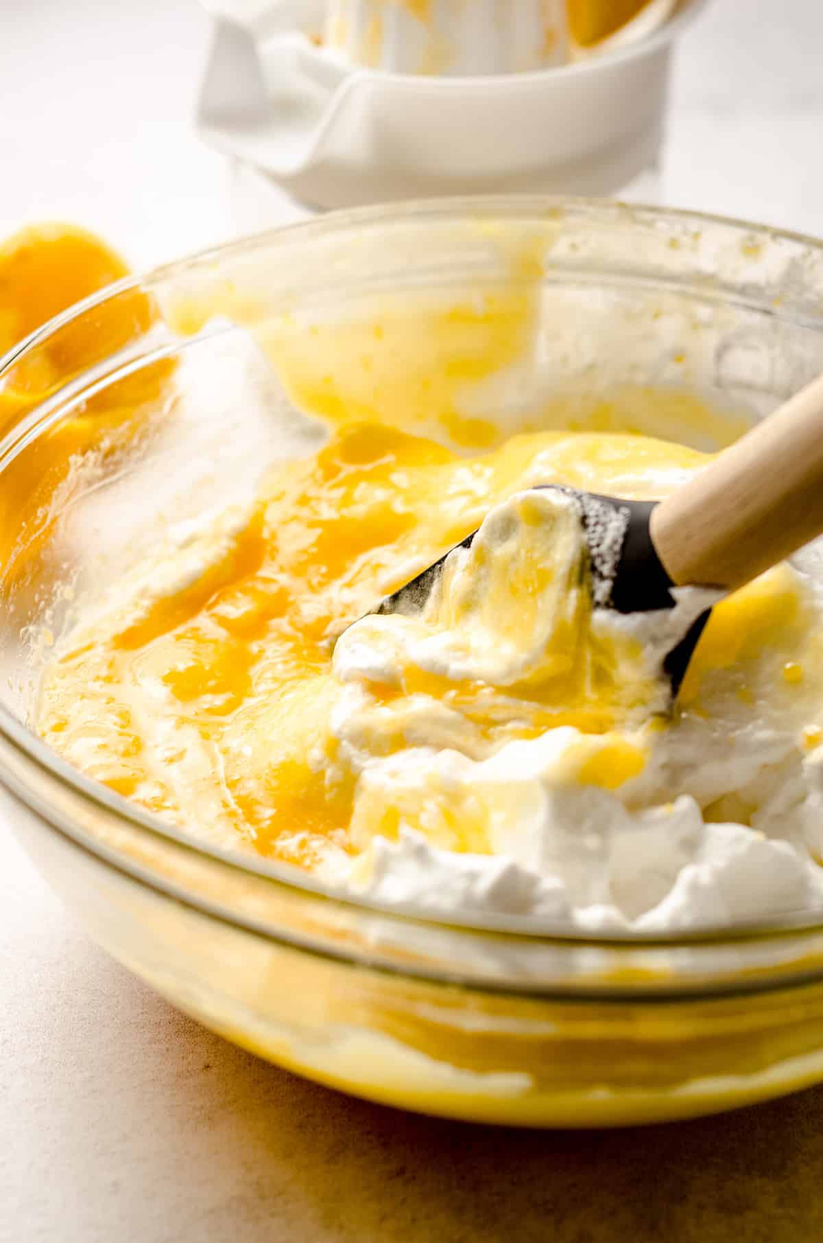 folding whipped egg whites into lemon custard for lemon mousse
