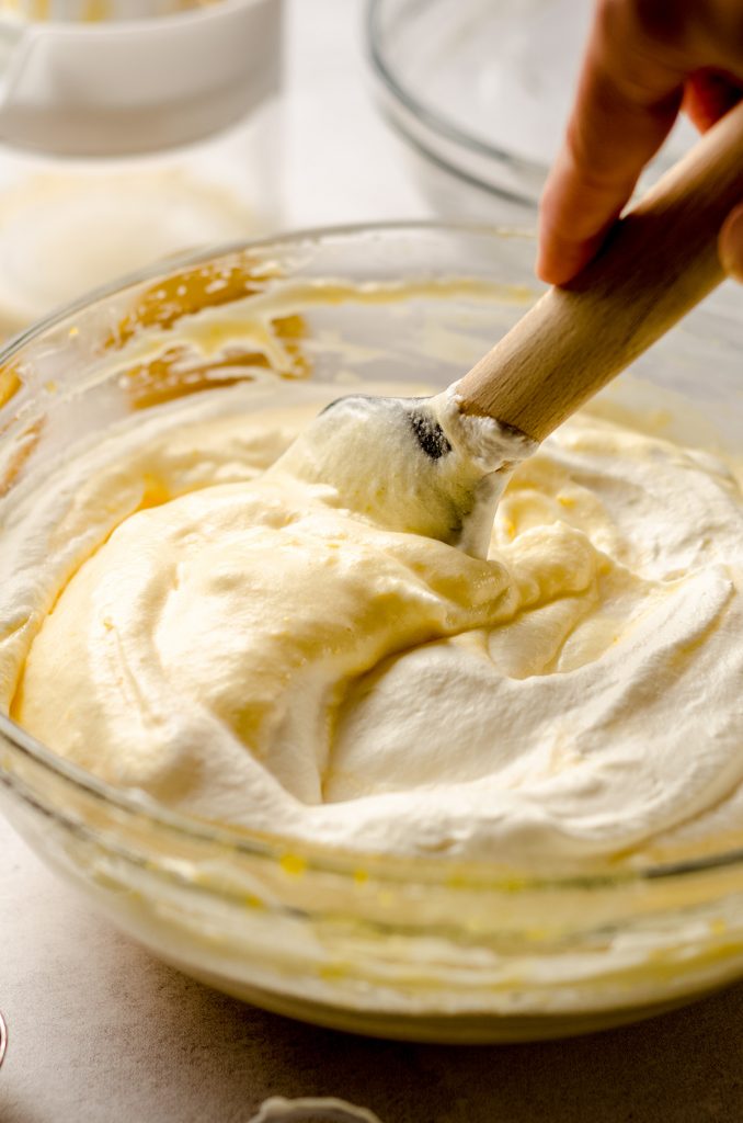 folding whipped cream into lemon custard to make lemon mouse