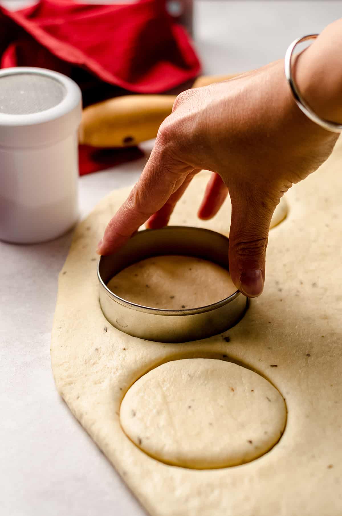 using a cookie cutter to cut circles of dough for pizza pull apart bread