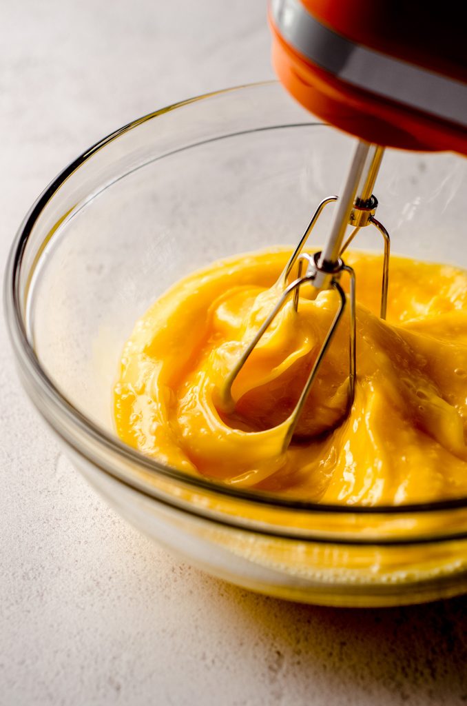 whipping eggs in a glass bowl